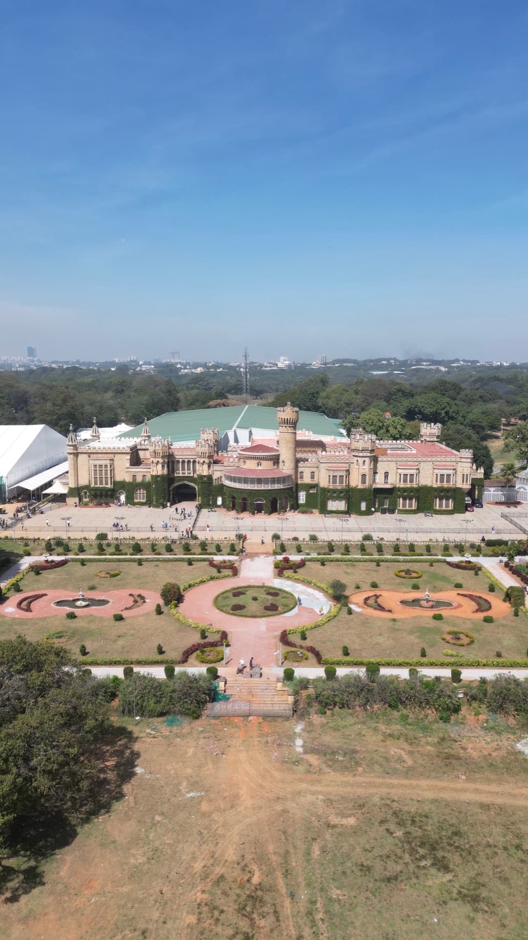Aerial drone photo of Bangalore Palace with formal gardens, symmetrical landscaping, and turrets from above