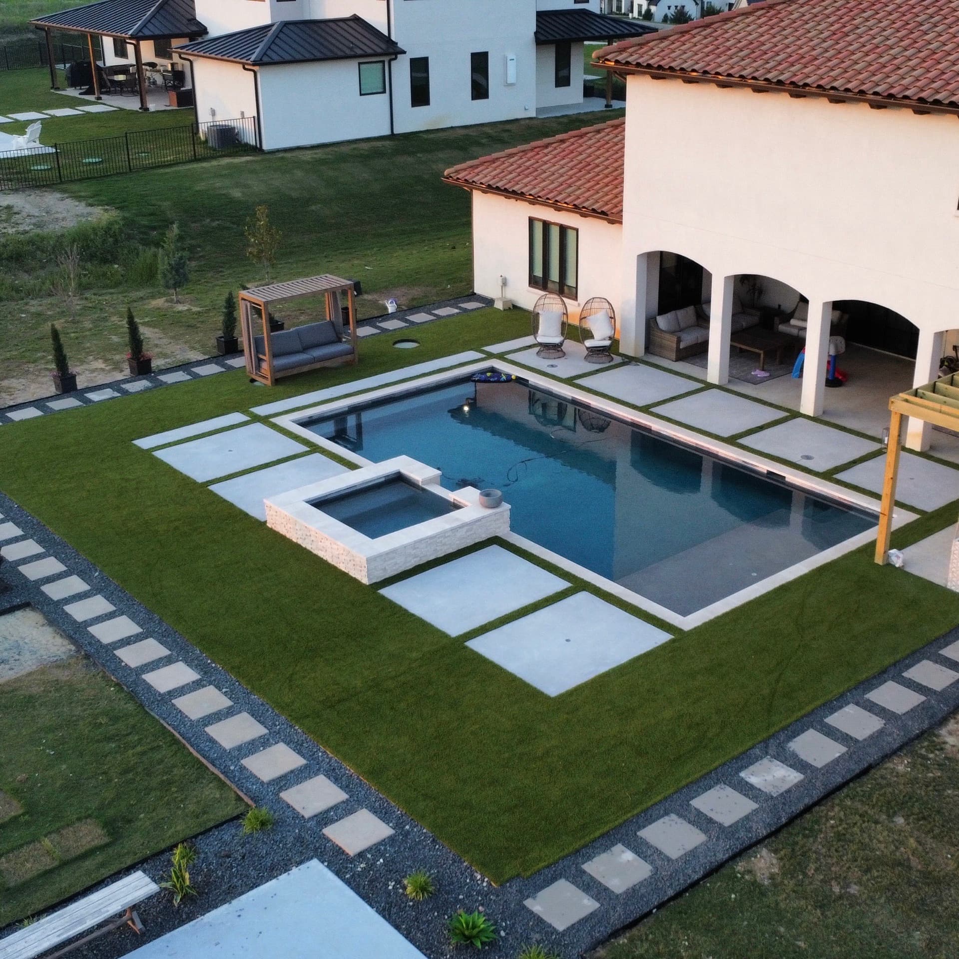 Aerial drone photo of luxury estate with pool, spa, and turf