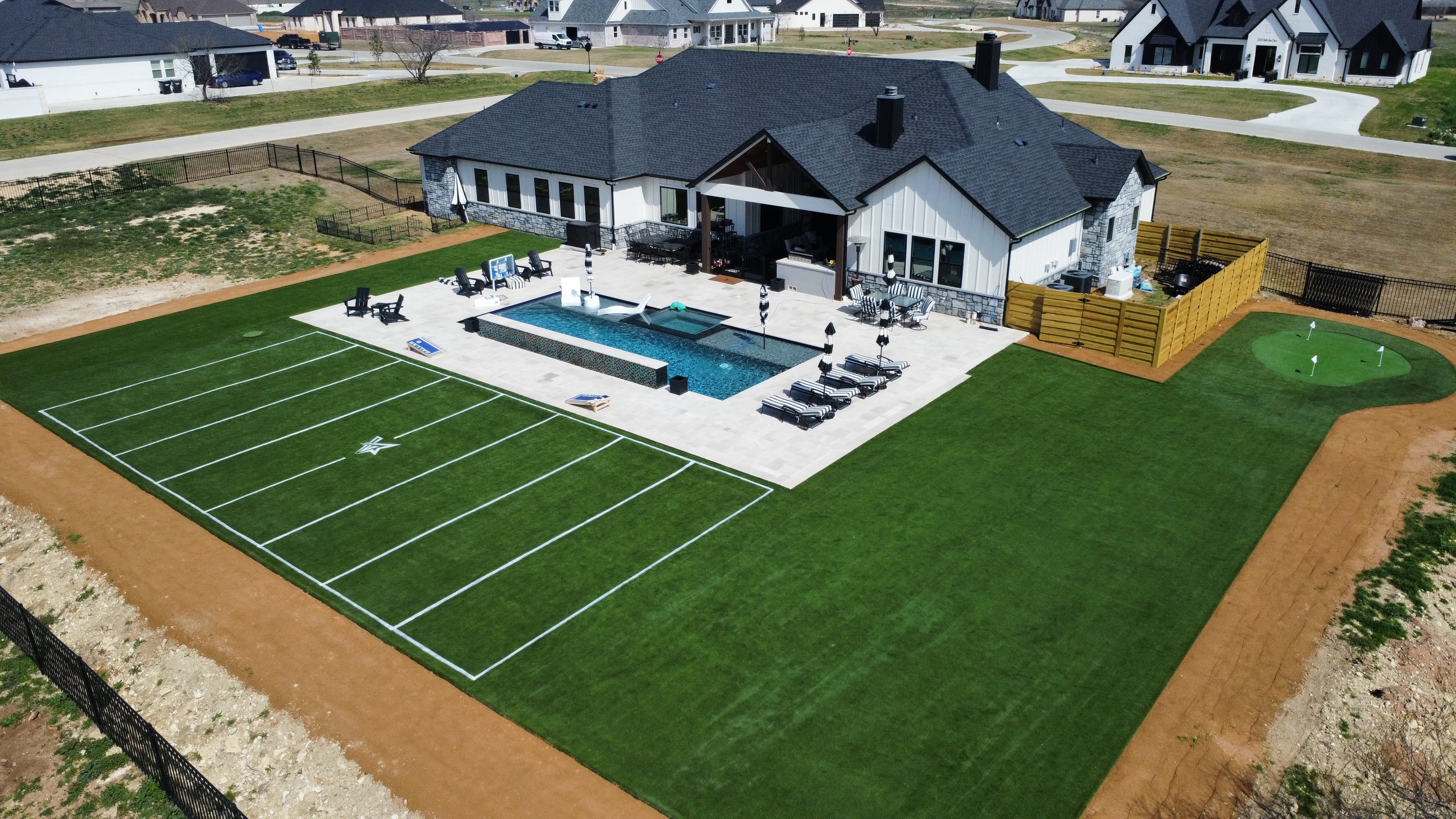 Overhead aerial of luxury home with private sports field, swimming pool, and basketball court